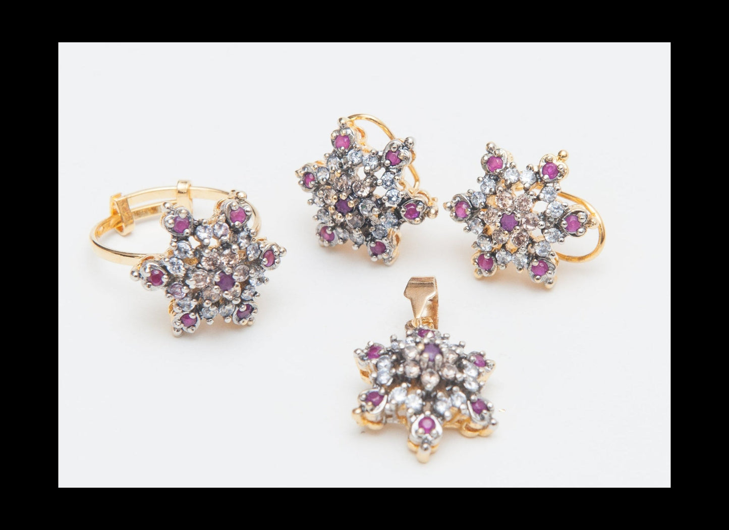 Set of gold jewelry with star-shaped designs and gemstones on a white background