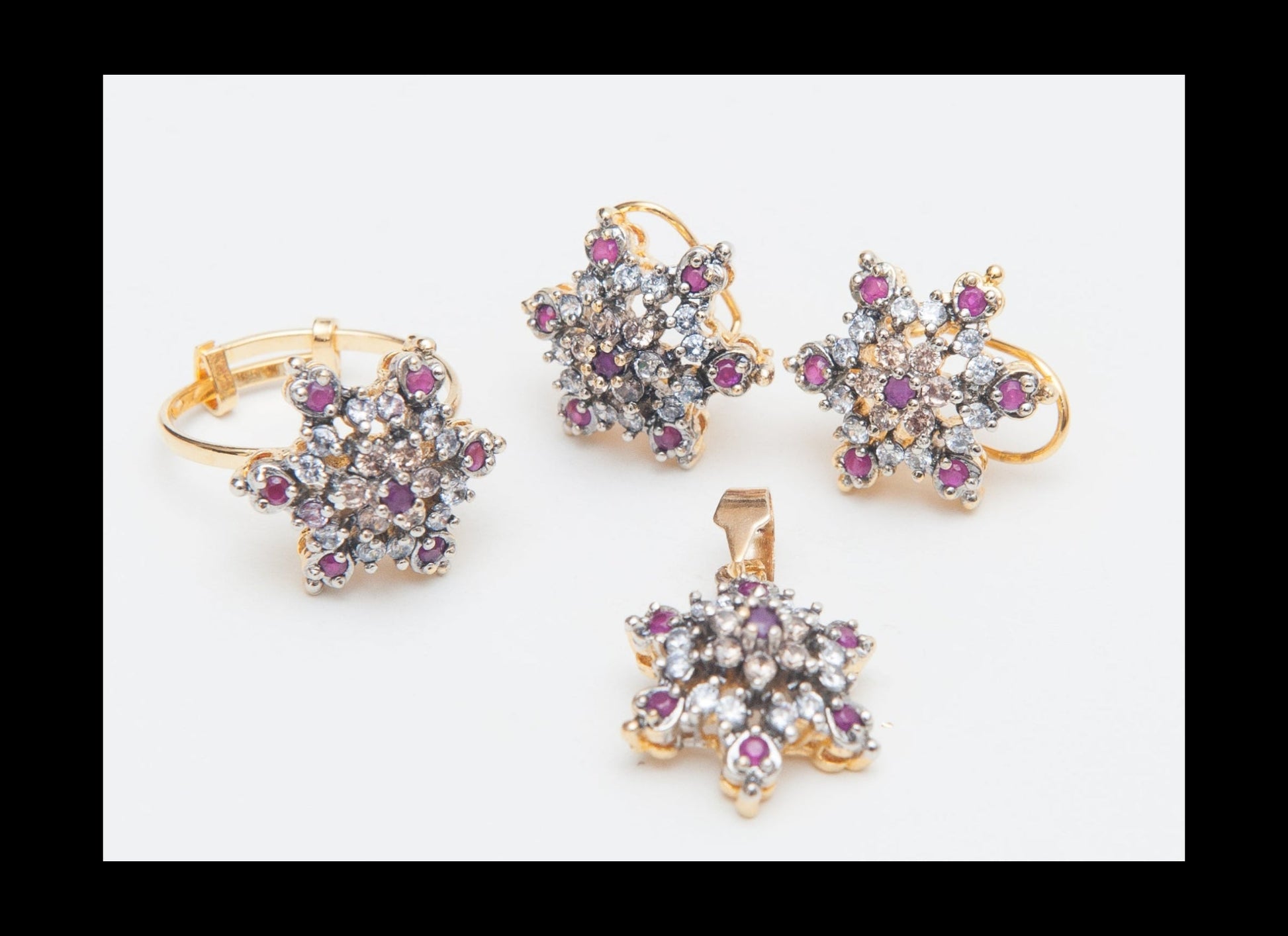 Set of gold jewelry with star-shaped designs and gemstones on a white background