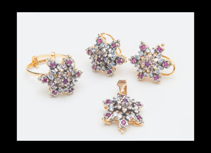 Set of gold jewelry with star-shaped designs and gemstones on a white background