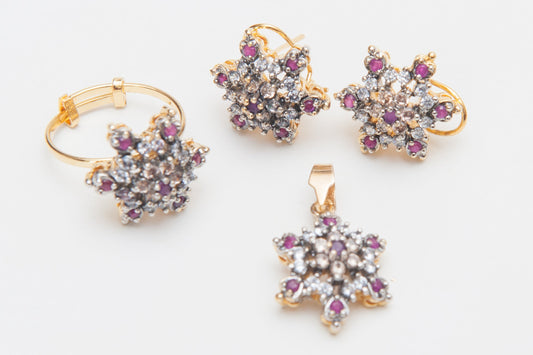 Gold jewelry set with star-shaped pendants and earrings on a white background