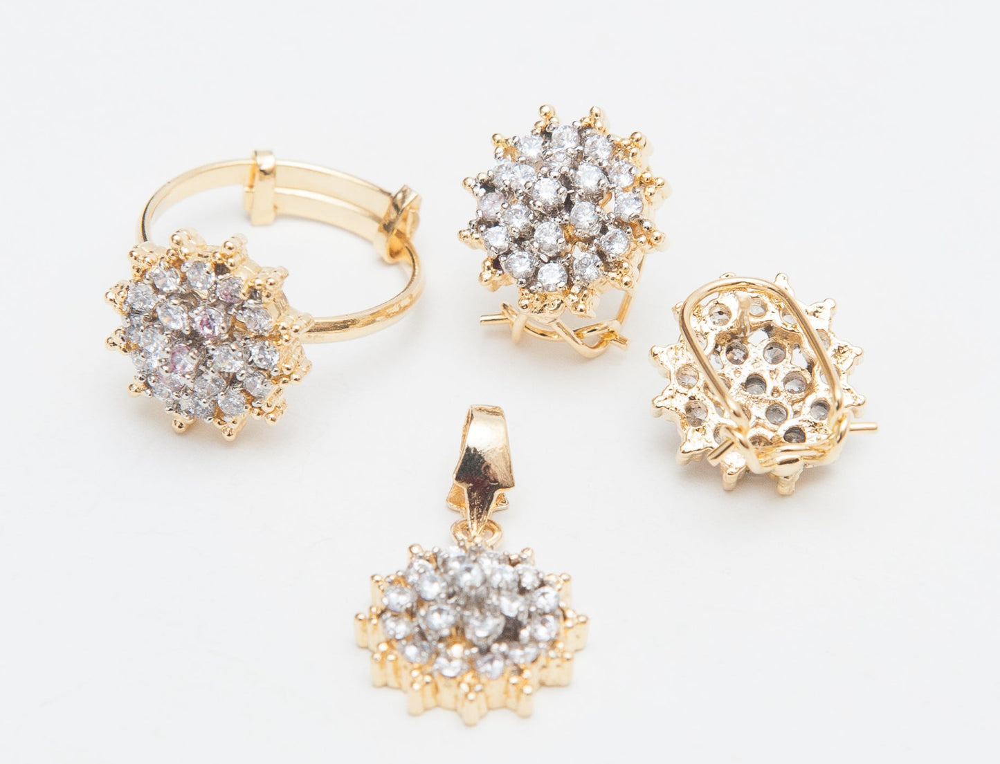 Gold and diamond jewelry set on a light gray background