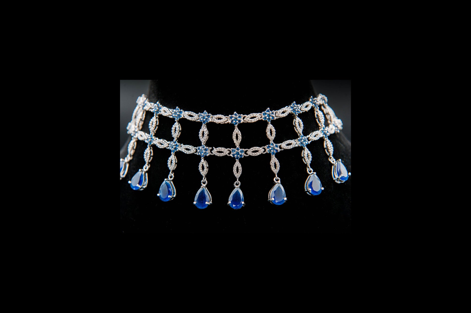 Silver necklace with blue gemstones on a black background